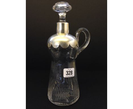 A silver mounted cut glass decanter with clear glass handle. 