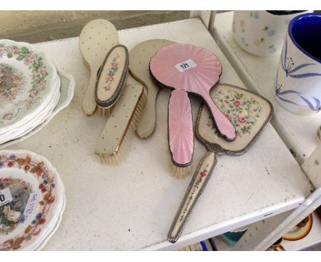 An enamel and silver backed dressing table hand mirror and brush together with the residue of other brush sets (latter not si