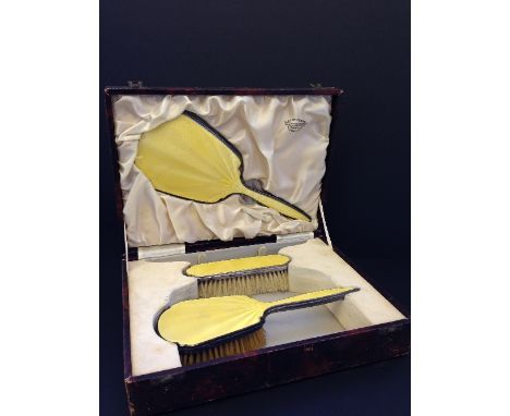 A yellow silver and enamel hairbrush and mirror set in original silk lined case.