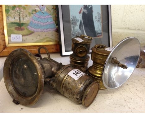 An early 20th century metal cycle lamp together with two others.