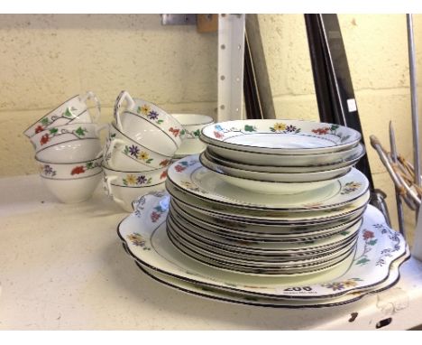The residue of an early 20th century bone china tea service decorated in a simple enamelled floral pattern.