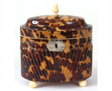 A RARE EARLY 19TH CENTURY REGENCY OVAL PRESSED TORTOISESHELL AND IVORY TEA CADDY with hinged top revealing a paper-lined inte