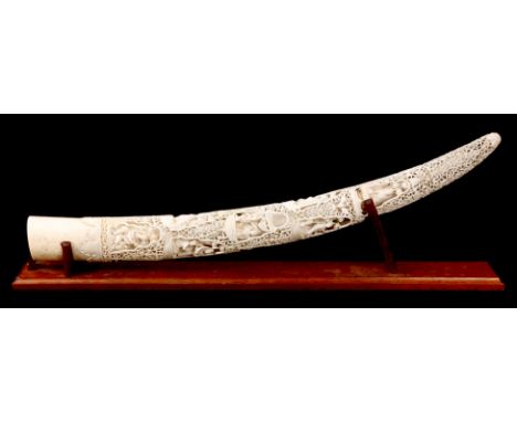 A 19TH CENTURY INDIAN CARVED IVORY TUSK with finely pierced and carved foliate scrollwork decoration inset with figures and e