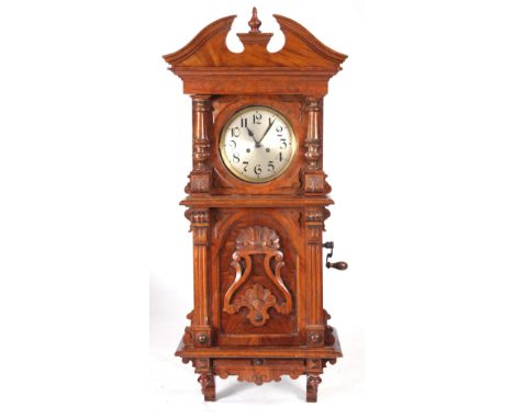 A LATE 19th CENTURY GERMAN SYMPHONION MUSIC BOX WALL CLOCK with elaborate walnut case enclosing an 8" silvered Arabic dial fr