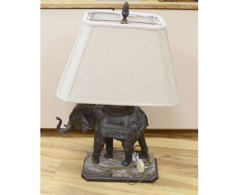 A bronzed elephant table lamp raised on shaped base, with shade, 79cm high