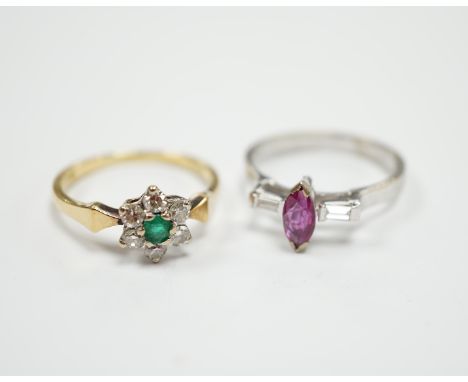An 18ct, emerald and diamond set flower head cluster ring, size N and an 18ct white metal ruby and diamond set three stone ri