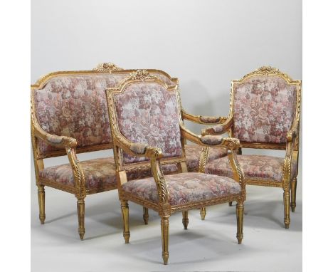 A French style upholstered gilt framed three piece suite, comprising a pair of open armchairs and a matching sofa, with flora