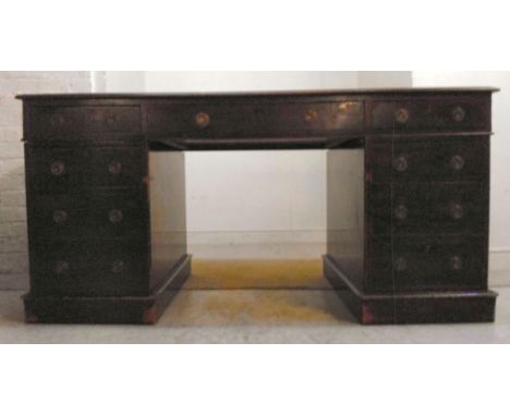 A late Victorian/Edwardian mahogany desk, the top having a tooled and gilded sage green hide scriber and a thumb moulded edge