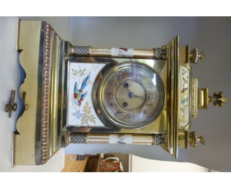 A late 19th/early 20thC Continental lacquered brass and painted porcelain cased mantel clock with flame and vase finials and 