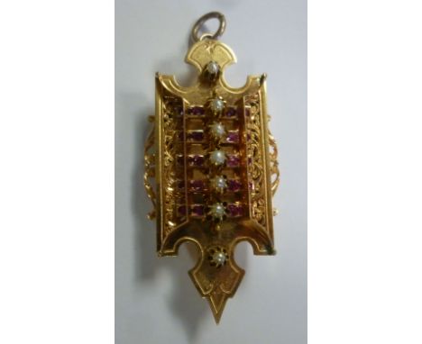 A late Victorian engraved and foliate scroll cast pendant brooch, set with ruby coloured stones and seed pearls