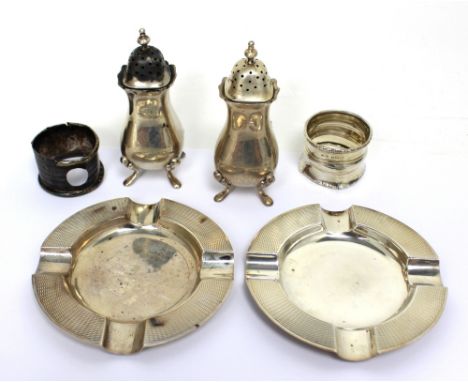 A pair of Elizabeth II hallmarked silver engine-turned ashtrays, two hallmarked silver napkin rings (af) and two hallmarked s