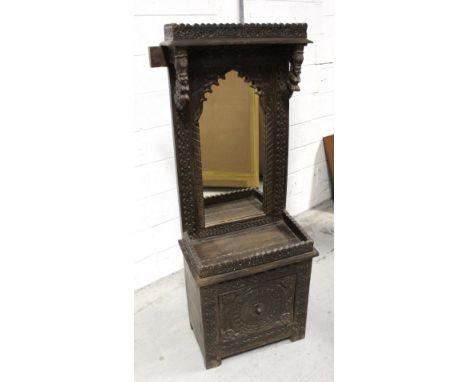 A 19th century Indian hardwood carved mirror stand, floral carved frieze over a rectangular mirror with arched top, floral ca