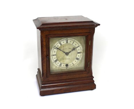 Morath Bros, Liverpool; an oak-cased mantel clock, the silvered circular dial set with Roman numerals, paper retailer's label