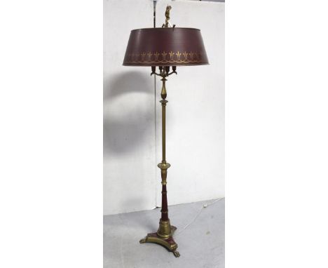 An early 20th century brass and maroon four-branch Regency-style standard lamp. shell decoration to base on tripartite suppor