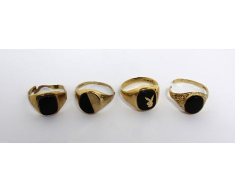 Four 9ct gold dress rings, all set with onyx stones; one with a gold Bunny Club motif, size R (three af) (4). CONDITION REPOR