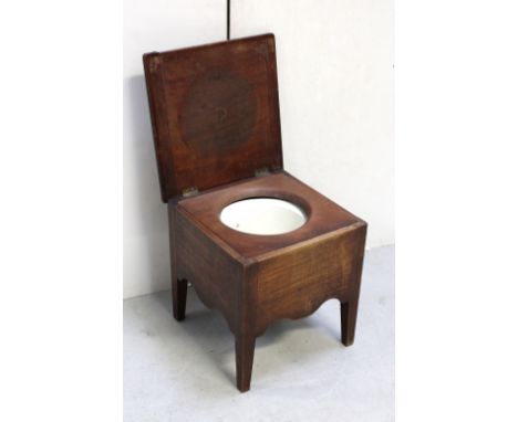 A 19th century mahogany commode with hinged lid enclosing ceramic liner.