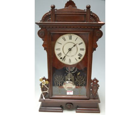 An early 20th century continental walnut cased mantel clock having an enamel dial with Roman numerals and eight day movement 