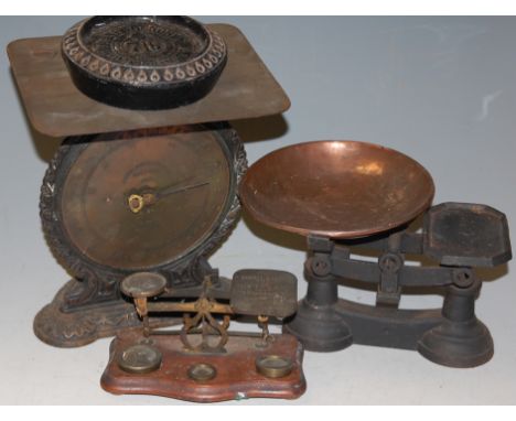 A pair of early 20th century brass postal scales, with weights; together with a cast iron kitchen scale; and a Salter parcel 