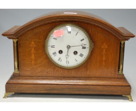 An Edwardian oak and satinwood inlaid mantel clock, of architectural form, having enamel dial with Roman numerals, eight day 