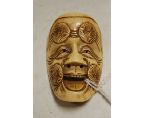 A small carved bone netsuke in the form of a mask Condition Report / Extra Information Scratches to centre of head and to the