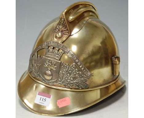 A WWI period French brass fireman's helmet, having applied badge with flaming grenade flanked by laurel and oak leaves, with 