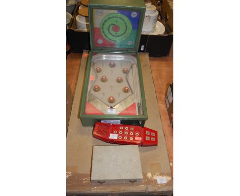 A mid 20th century table top pinball machine together with a Pallitoy Merlin telephone game, travelling chess set, and bagate