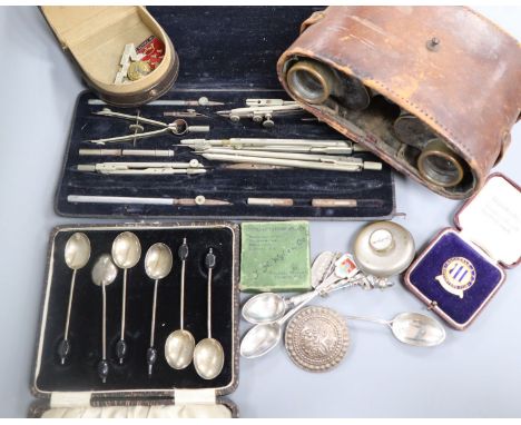 A pair of military binoculars, badges, a compass, two silver spoons etc