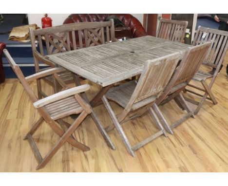A teak garden table, bench and five chairs Table 150cm