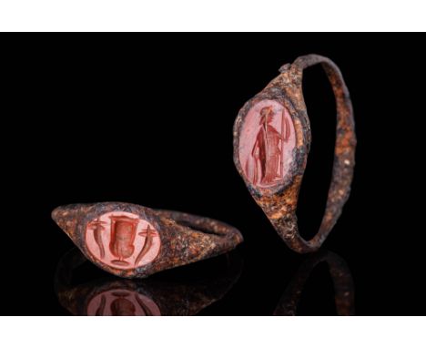 Ca. AD 1 - 300.A pair of rings, each with a flat-section thin hoop that gently flares towards the bezel. Each bezel is set wi