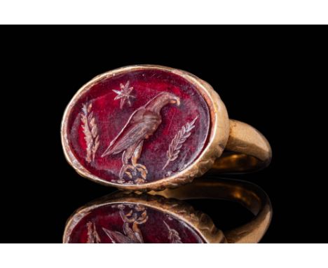 Ca. AD 1 - 100.An oval-shaped red garnet intaglio, finely engraved with the image of the imperial eagle taking centre stage. 