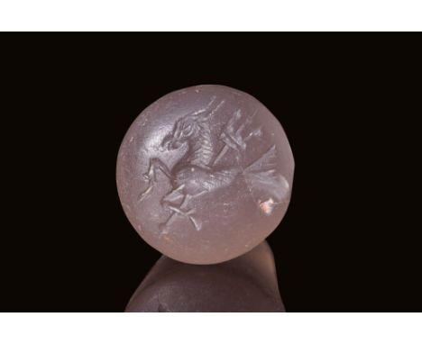 Ca. 500 - 400 BC.A chalcedony stamp seal, pyramid-shaped with a rounded, pierced top and a convex circular base. The engravin
