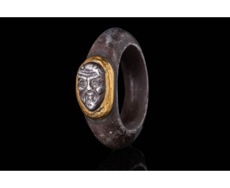 Ca. AD 1 - 300.A silver ring of annular form, featuring a hollow band with a prominent curvature. The ring is set with a rais