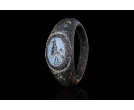 Ca. AD 1 - 300.A bronze ring composed of a rounded hoop with a D-section profile and expanded shoulders. The bezel is set wit