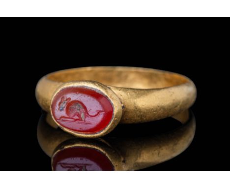 Ca. AD 1 - 100.An oval-shaped carnelian intaglio engraved with a crouching mouse positioned on a baseline. The mouse has a ro