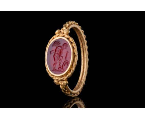 Ca. AD 200 - 400.An oval-shaped carnelian intaglio depicting a youthful warrior standing with his left leg raised on a rock. 