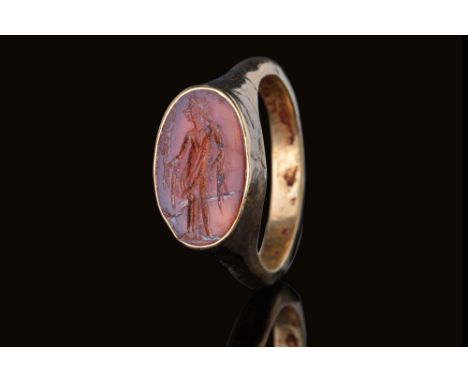 Ca. AD 1 - 200.An oval-shaped carnelian intaglio engraved with a standing figure of the god Apollo. The god is shown with his