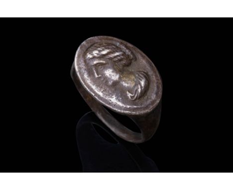 Ca. AD 200 - 225.A silver ring with a flat-section hoop, gradually expanding to support a large, oval-shaped bezel. The bezel