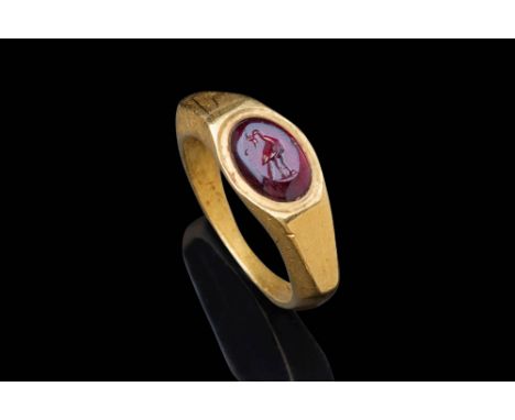 Ca. AD 200 - 300 .An oval-shaped red garnet intaglio, convex in profile, depicting a peacock standing on a lightly defined ba