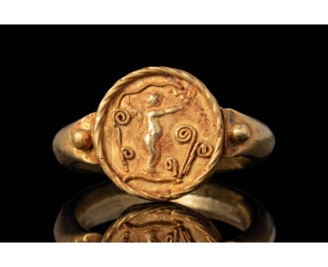 Ca. AD 100 - 300.A Roman gold ring with a D shaped band with enlarged shoulders leading towards a round bezel depicting a win