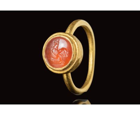 Ca. AD 500 - 600. A gold ring with a round band and round bezel securing a carnelian intaglio depicting a rooster. For simila