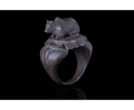 Ca. AD 1400.A substantial bronze ring with a broad hoop and wide, sculpted shoulders marked by two engraved horizontal lines 