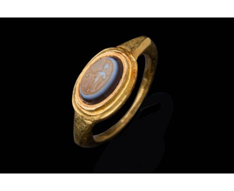 Ca. AD 200 - 300 .A banded agate intaglio, oval-shaped and convex, depicting the standing figure of Mercury, the messenger go