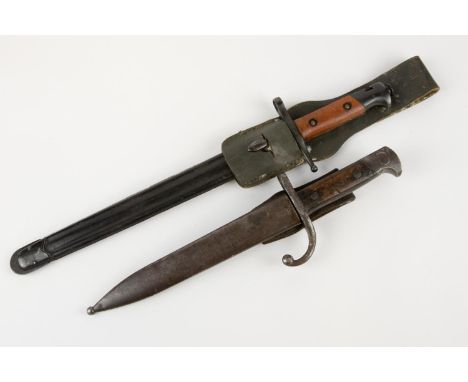 An Italian M1891/97 Carcano Truppi Speciali bayonet, with pale wood grips and black lacquered finish overall, in its ribbed l