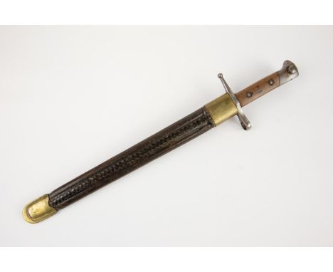 An Italian M1891 Carcano bayonet, in its brass mounted fluted leather scabbard. GC £50-70 