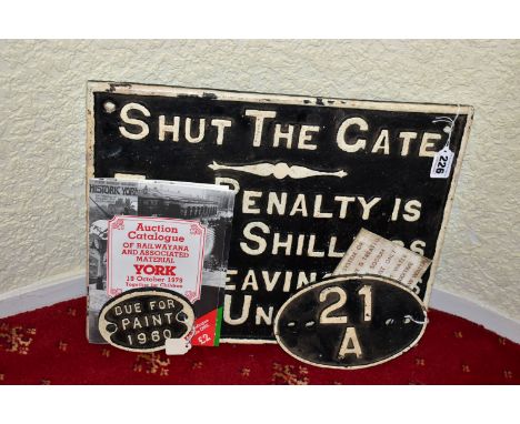 A CAST IRON SHUT THE GATE PENALTY NOTICE, raised white lettering and edge surround on black background, fixing holes to each 