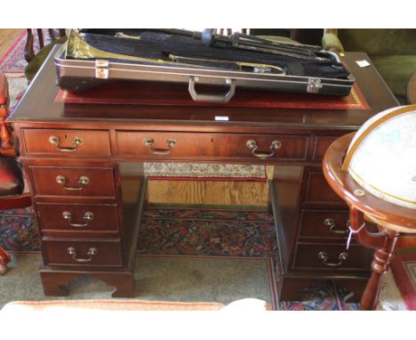 A Georgian-style mahogany twin pedestal desk with shaped top, red leather inset, frieze drawer with eight-drawers under with 