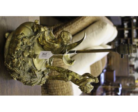 A highly ornate brass lamp stand supported by cherubs and stylised foliage on a circular base, 40cm high 