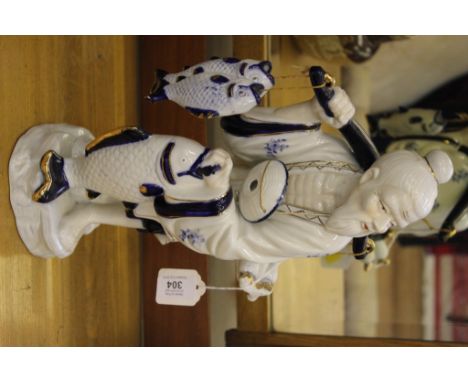 A ceramic figurine of a Chinese fisherman on a stylized base, 37cm high 