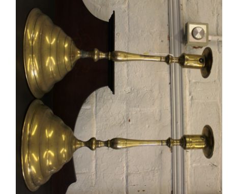 A pair of early 20th century brass candle holders or lamp stands with baluster shaped central column on a stepped circular ba