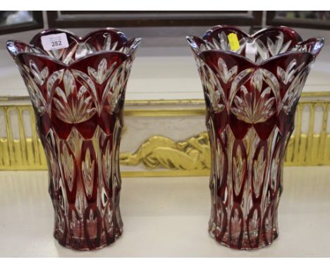A pair of ruby-ground Bohemian glass vases with wavy rim tops and fern depictions, each 30cm high 